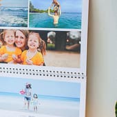 Premium photo calendar with family beach photos displayed on a wall