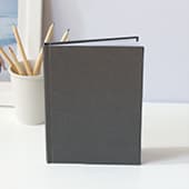 Journal with grey hardcover standing on desk