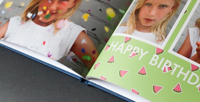 Open photo book with HD lustre finish, featuring colourful birthday-themed pages.