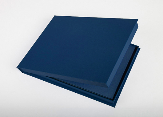 Blue clamshell presentation box for photo book, open to show interior.